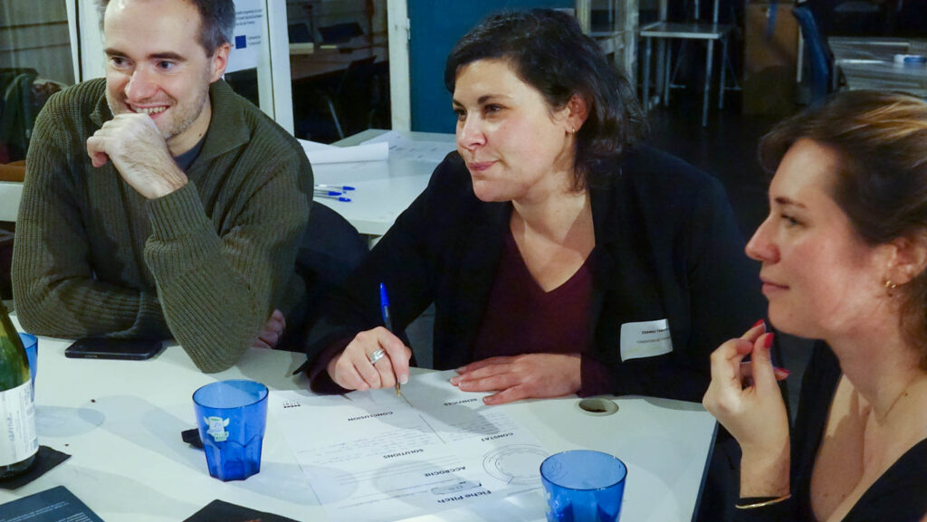 3 personnes en train de discuter autour d'une table